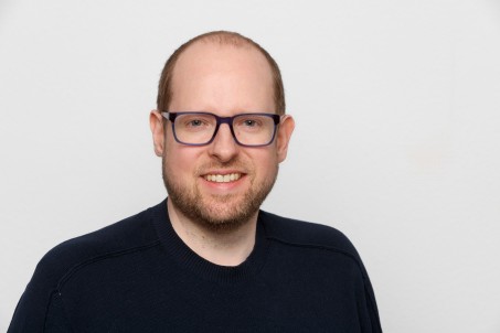 Dennis Theophil lächelt in die Kamera.