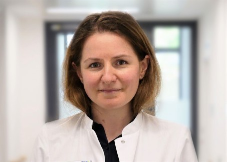 Portrait von Frau Kovach mit einem weißen Kittel im Flur des Klinikums