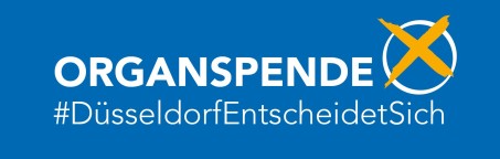 Weiße Schrift: Organspende #Düsseldorf Entscheidet sich auf blauem Hintergrund. Rechts oben in der Ecke ein weißer Kreis mit einem orangenen Kreuz darin