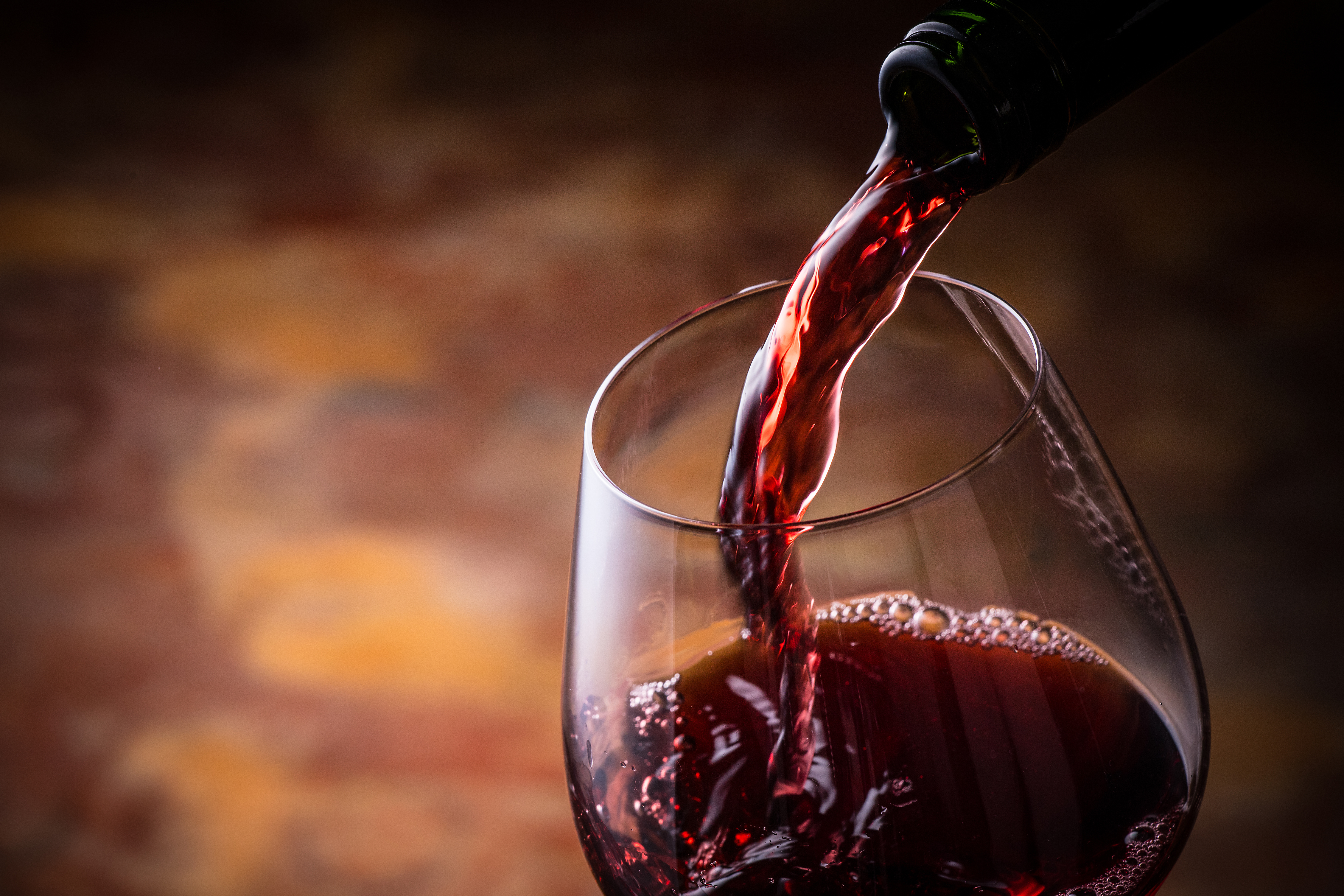 Ein Weinglas in das Rotwein gefüllt wird