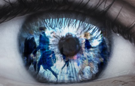 Auge in dem sich Menschen in einer Fußgängerzone spiegeln