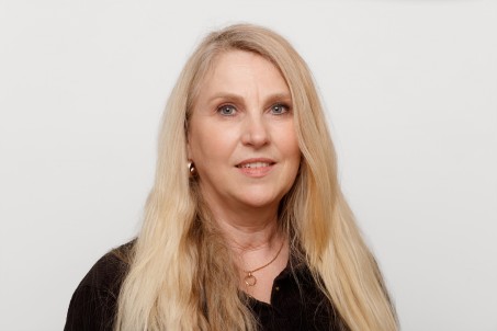 Porträt von Kirsten Berndt. Sie trägt eine schwarze Bluse und lächelt in die Kamera