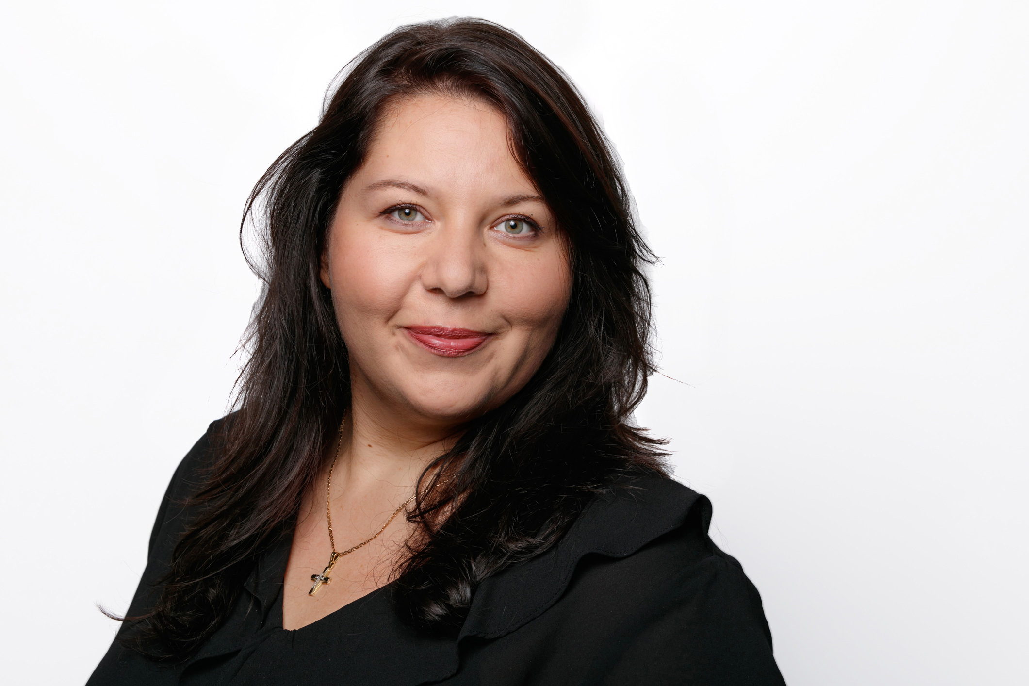 Ein Portrait einer Frau mit langen schwarzen Haaren und einer schwarzen Bluse