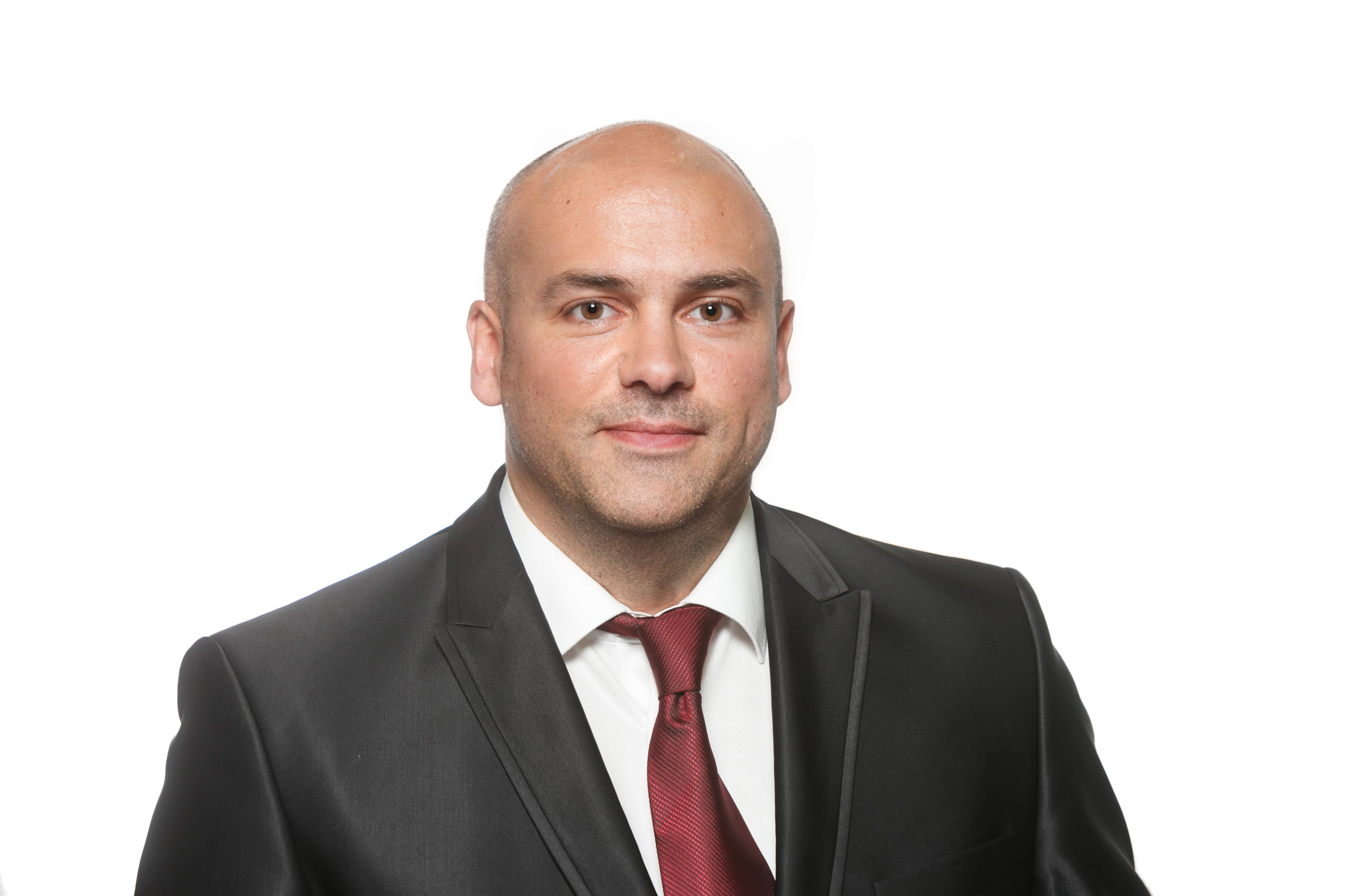 Ein Portrait eines Mannes mit einem schwarzen Jackett und einer roten Krawatte