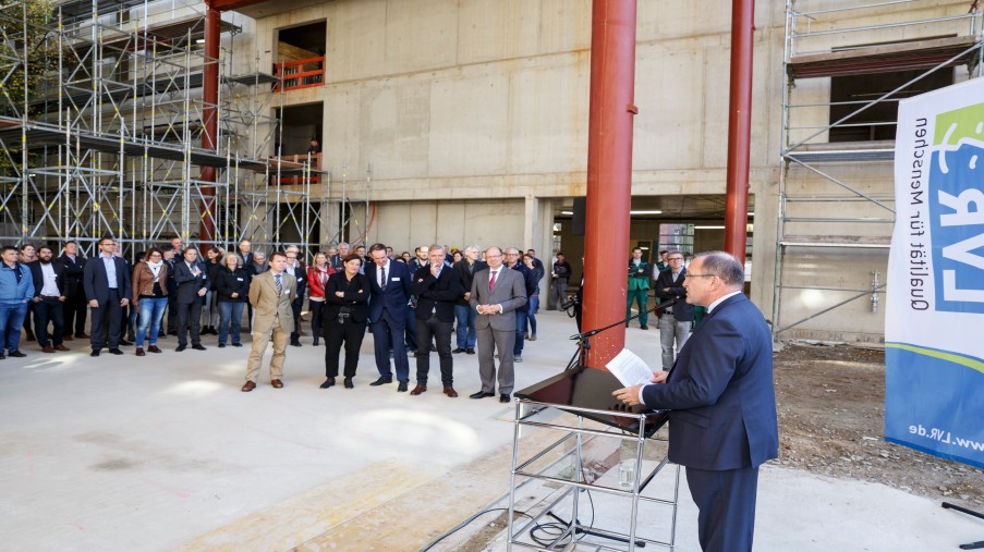 Redner und Zuhörer vor dem Rohbau des DTFZ