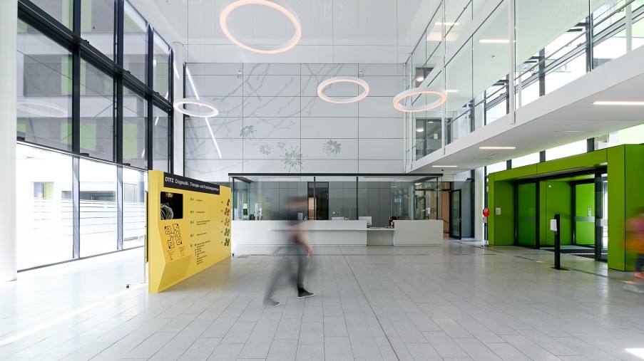 Die Eingangshalle mit einer gelben Infotafel und einem Infoschalter 