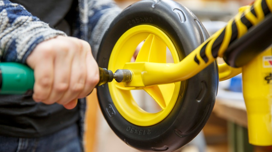 ein Rad eines Kinderfahrrads wird montiert