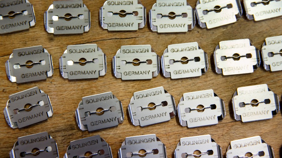 Eine Reihe von bearbeiteten Rasierklingen auf einenm Tisch ausgelegt.