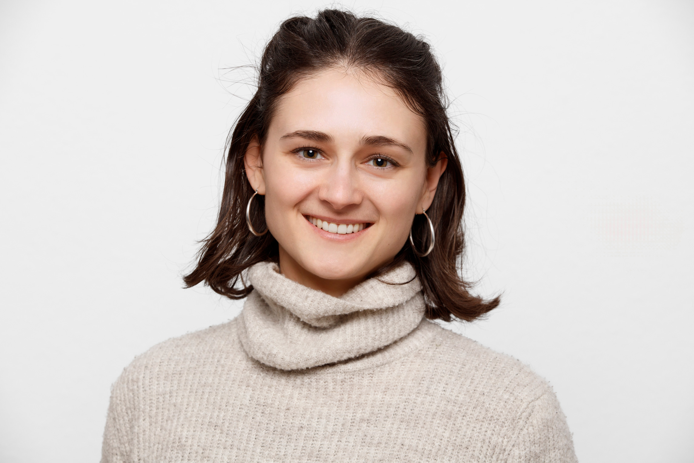 Porträt von Tamara Ringel. Sie trägt einen beigen Pullover und lächelt in die Kamera.