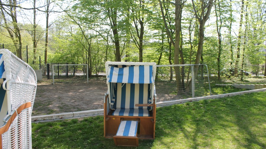 Ein Strandkorb steht im Garten auf einer Wiese