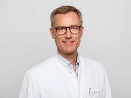 Portrait von Prof. Til Menge in weißem Kittel