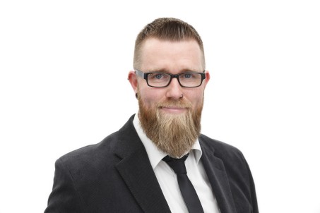 Portrait von Mato Charlier. Er trägt einen Anzug mit Krawatte