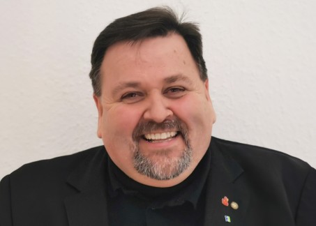 Porträt eines Mannes mit schwarzem Jackett und dunklen kurzen Haaren