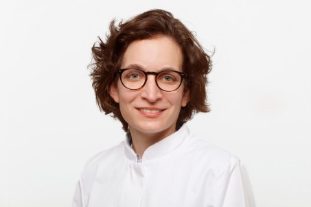 Porträt von Francesca Pessanha-Schlegel. Sie trägt einen weißen Kittel und lächelt in die Kamera.