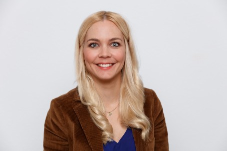 Porträt von Kathrin Schiffner. Sie trägt einen braunen Blazer und lächelt in die Kamera