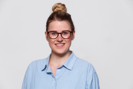 Porträt von Frau Isenberg in hellblauer Bluse vor einem weißen Hintergrund