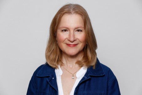 Porträt von Frau Egli-Vonderau in blauer Jacke vor einem weißen Hintergrund